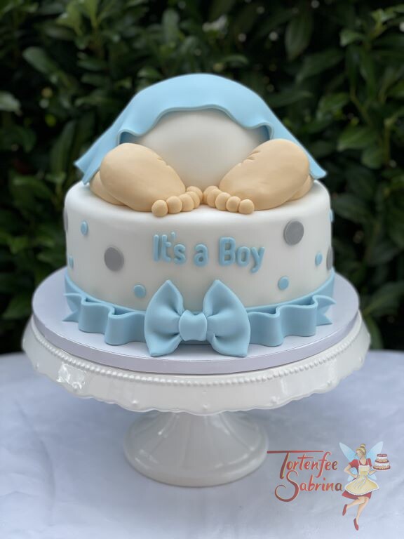 Babytorte - Babyfüsschen und blaue Schleife am unteren Ende zieren die Torte, die Decke ist ebenfalls blau.