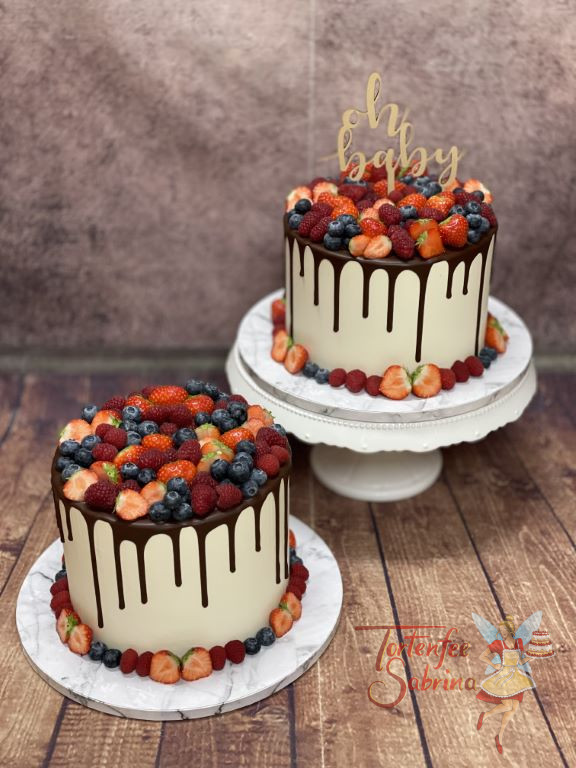 Babytorte - Leckere Beeren in verschiedenen Geschmacksrichtungen und ein Caketopper verzieren die beiden Drip Cakes.