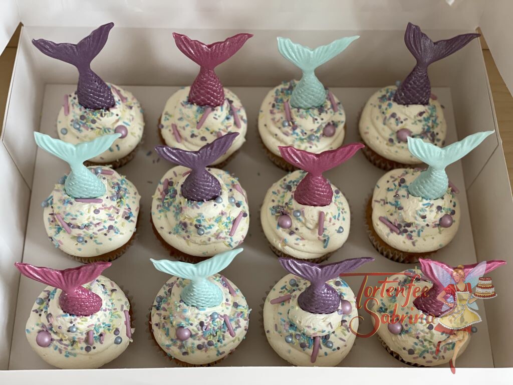 Cupcakes - Meerjungfrauenflossen und Zuckerstreusel mit Zuckerkugeln in den Farben rosa, violett und türkis zieren die Cupcakes.