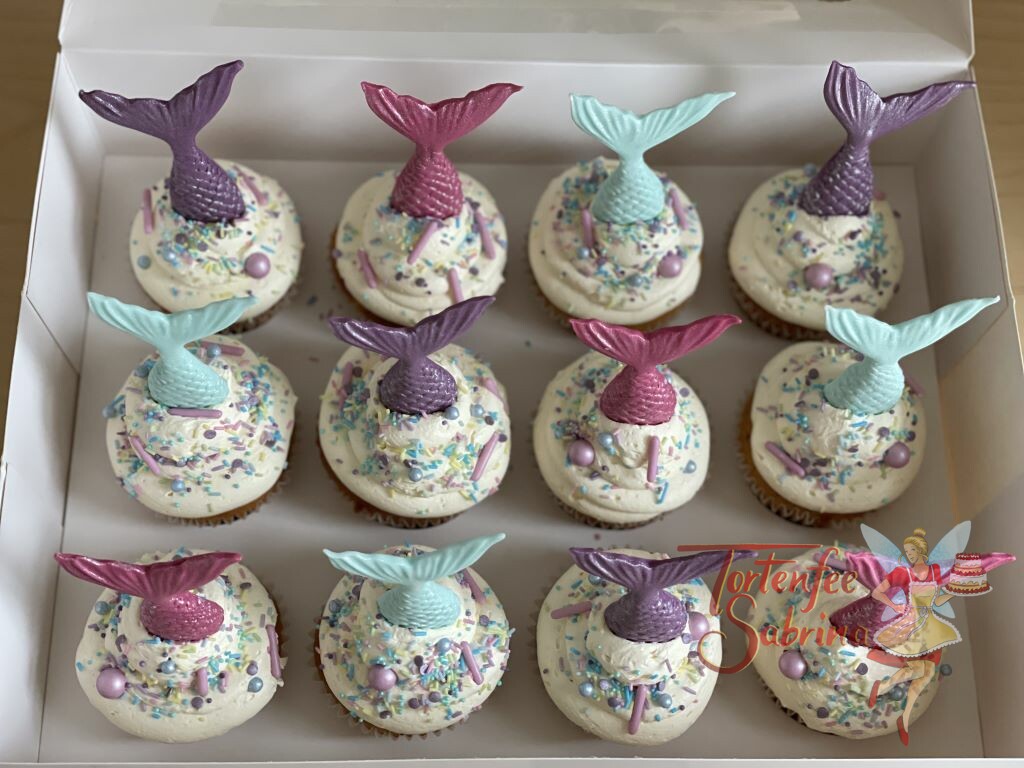 Cupcakes - Meerjungfrauenflossen und Zuckerstreusel mit Zuckerkugeln in den Farben rosa, violett und türkis zieren die Cupcakes.