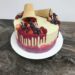 Drip Cake mit selbstgefärbter Schokolade dekoriert mit Früchten und rotem Drip