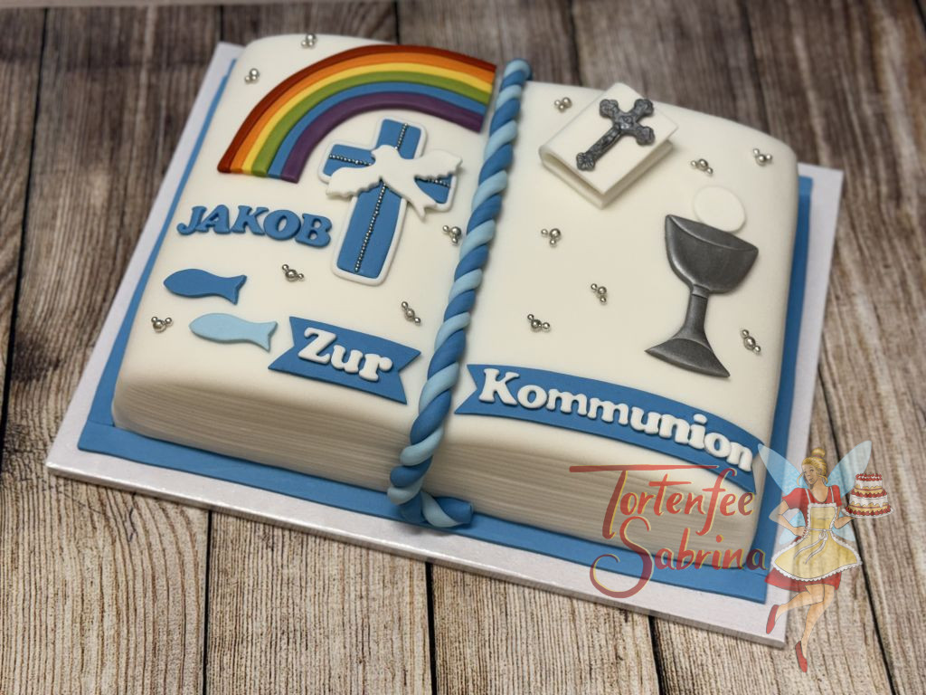 Erstkommunionstorte - Buch mit Regenbogen und anderen typischen Symbolen wie Kreuz und Kelch verzieren die Torte.