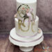 Erstkommunionstorte - Goldene Silhouette eines betenden Mädchens mit Blumenschmuck im Haar verziert die Front der Torte.