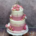Erstkommunionstorte - Rosa Kugeln und auch Weisse verzieren die mehrfärbig eingestriche Torte mit goldenem Caketopper.
