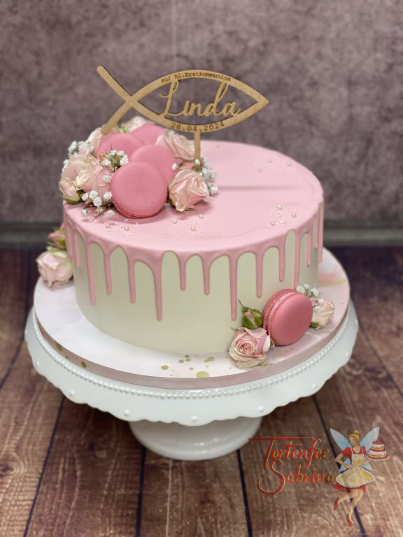 Erstkommunionstorte - Rosa Macarons mit zarten rosa Macarons verzieren neben dem personalisierten Caketopper den Drip Cake.