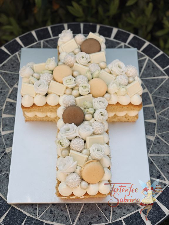 Firmungstorte - Süßes Kreuz würde hier mit Macarons, Schokolade und weißen Blumen verziert.