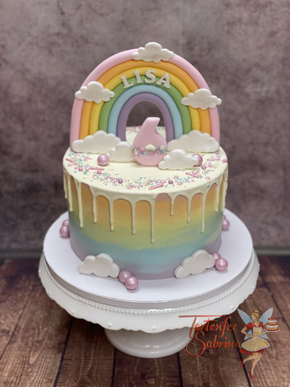 Geburtstagstorte Mädchen - Alle Farben des Regenbogen sind auf dieser Torte seitlich zu sehen, gekörnt von einem weißen Drip.