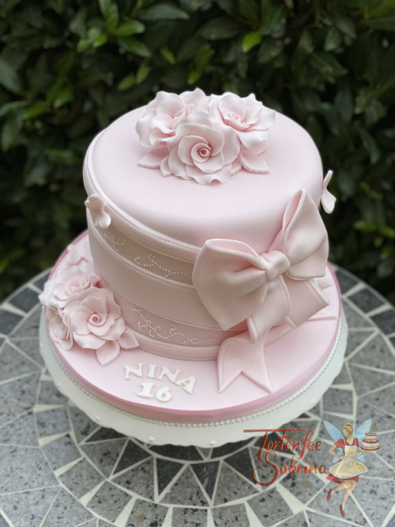 Geburtstagstorte Mädchen - Alles in rosa ist das Thema der Torte, welche mit Blumen, Bändern und einer Schleife verziert wurde.