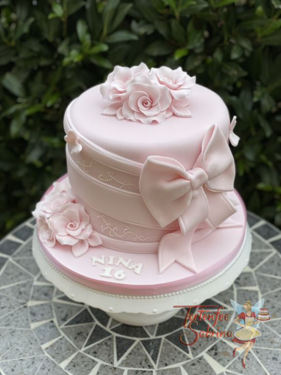 Geburtstagstorte Mädchen - Alles in rosa ist das Thema der Torte, welche mit Blumen, Bändern und einer Schleife verziert wurde.