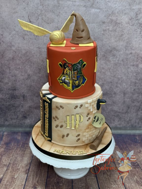 Geburtstagstorte Buben - Auf nach Hogwarts, beim Bahnsteig 9 3/4 geht es los. Ganz vorne auf der Torte ist das bunte Hogwartslogo.