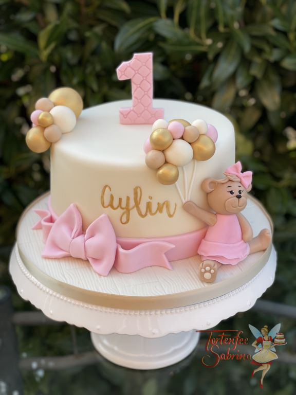 Geburtstagstorte Mädchen - Bärenmädchen mit Luftballons sitzt am Rand der Torte und freut sich über die vielen bunten Luftballons.