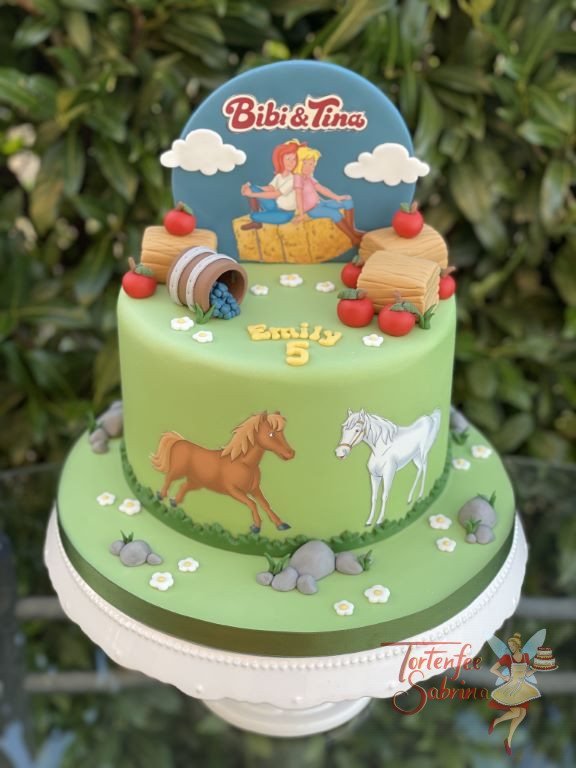 Geburtstagstorte Mädchen - Bibi und Tina rasten auf einem Strohpinkerl, mit auf der Torte sind natürlich ihre beiden Pferde.