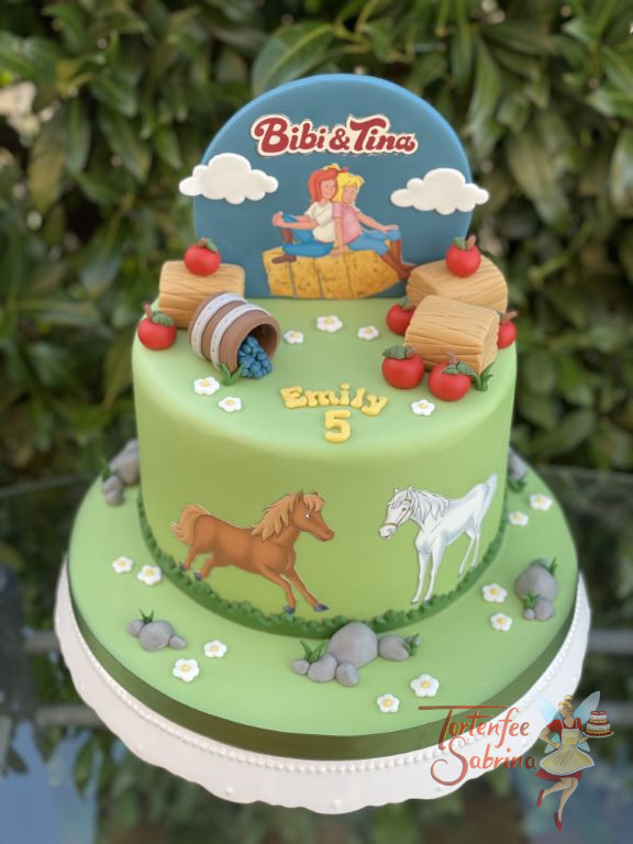 Geburtstagstorte Mädchen - Bibi und Tina rasten auf einem Strohpinkerl, mit auf der Torte sind natürlich ihre beiden Pferde.
