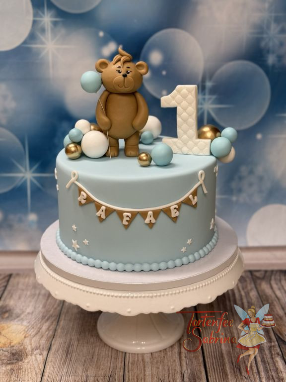 Geburtstagstorte Buben - Blaue Ballone werden von dem kleinen Teddybär gehalten und der Name ist auf der Wimpelkette.