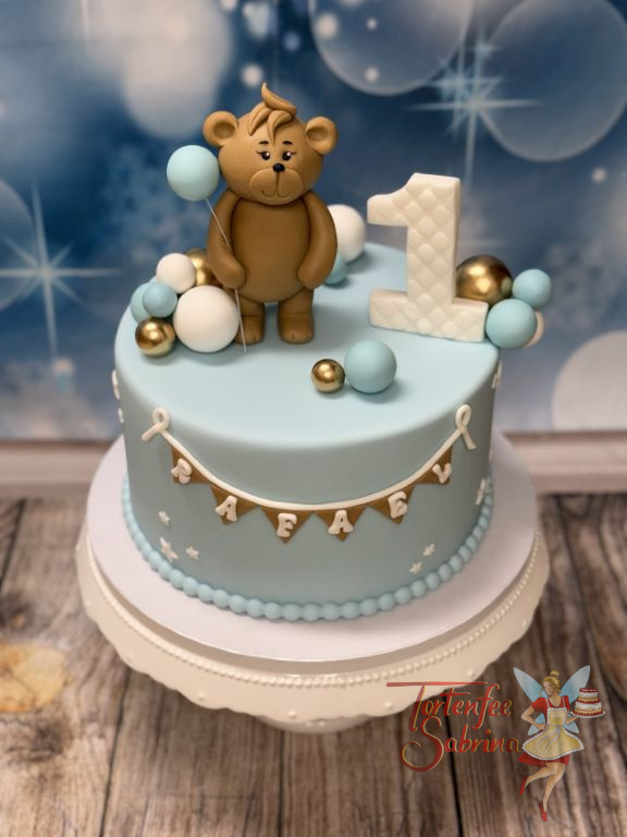 Geburtstagstorte Buben - Blaue Ballone werden von dem kleinen Teddybär gehalten und der Name ist auf der Wimpelkette.