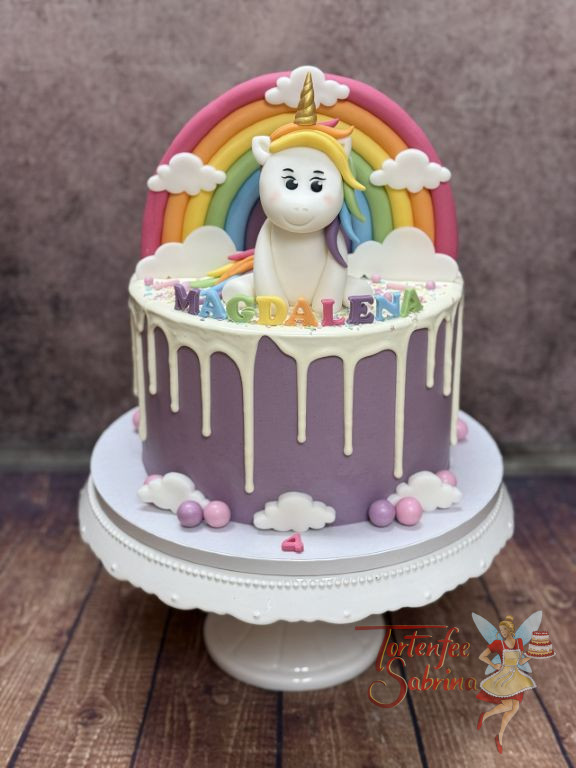 Geburtstagstorte Mädchen - Bunte Buchstaben des Geburtstagskindes sowie ein Einhorn und ein Regenbogen zieren oben die Torte.