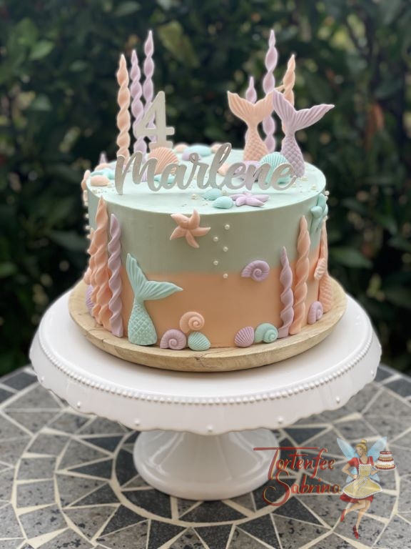 Geburtstagstorte Mädchen - Bunte Meerjungfrauenflossen verzieren neben vielen Muscheln und Korallen die zweifärbige Torte.