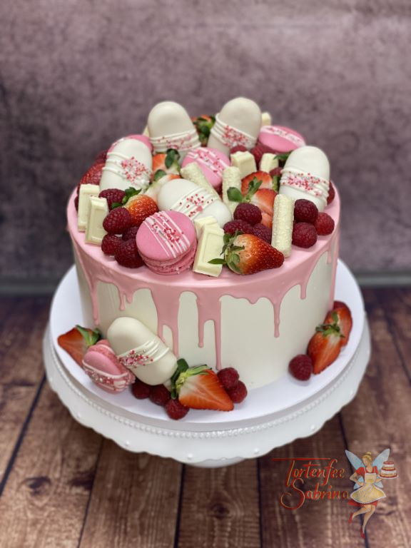 Geburtstagstorte Erwachsene - Cakesicles mit rosa Drip und Macarons verzieren diesen Drip Cake, ebenso sind noch Früchte auf der Torte.