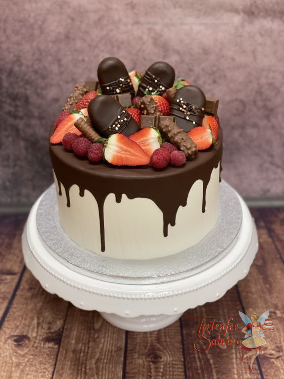 Geburtstagstorte Erwachsene - Cakesicles und Früchte verzieren den Drip Cake. Sehr viele rote Beeren befinden sich auf der Torte.