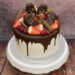 Geburtstagstorte Erwachsene - Cakesicles und Früchte verzieren den Drip Cake. Sehr viele rote Beeren befinden sich auf der Torte.