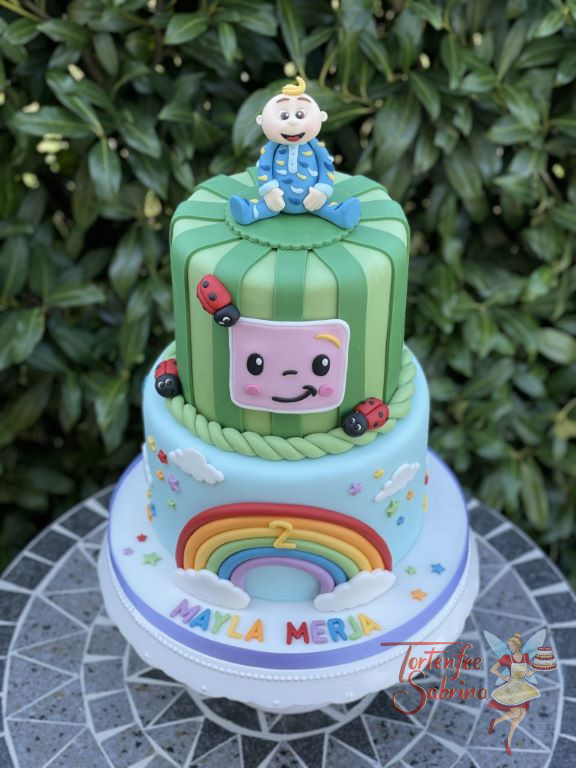 Geburtstagstorte Mädchen - Cocomelon, hier ziert ein bunter Regenbogen die untere Torte, oben ist das Baby Jacob Jingleheimer Schmidt.