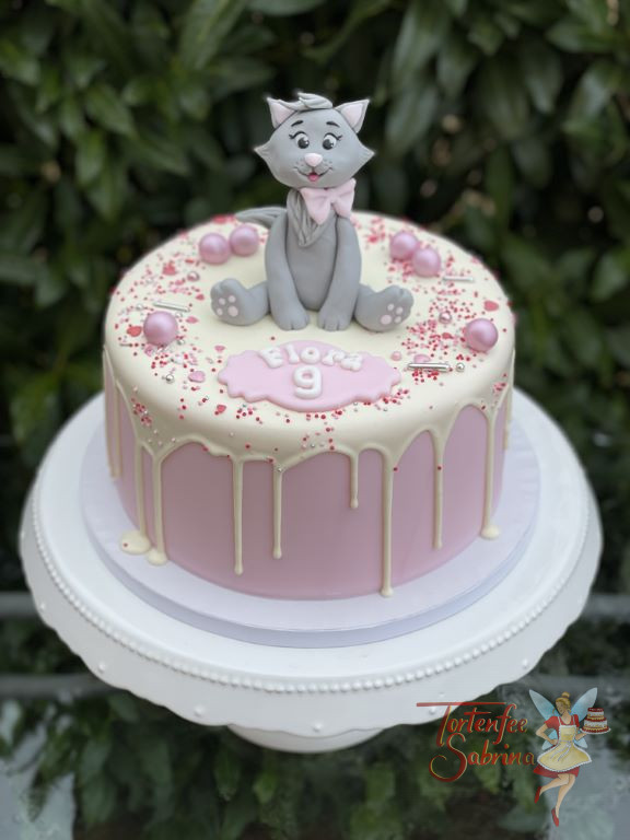 Geburtstagstorte Mädchen - Das lächelnde Kätzchen sitz oben auf dem Drip Cake, zusätzlich wurde die Torte mit Zuckerstreusel verziert.