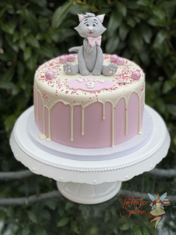 Geburtstagstorte Mädchen - Das lächelnde Kätzchen sitz oben auf dem Drip Cake, zusätzlich wurde die Torte mit Zuckerstreusel verziert.