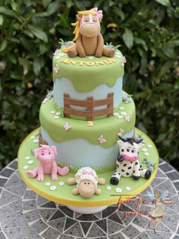 Geburtstagstorte Mädchen - Das Pferdchen mit blonder Mähne sitzt oben auf der Torte, unten seine Freunde das Schwein, das Schaf und die Kuh.
