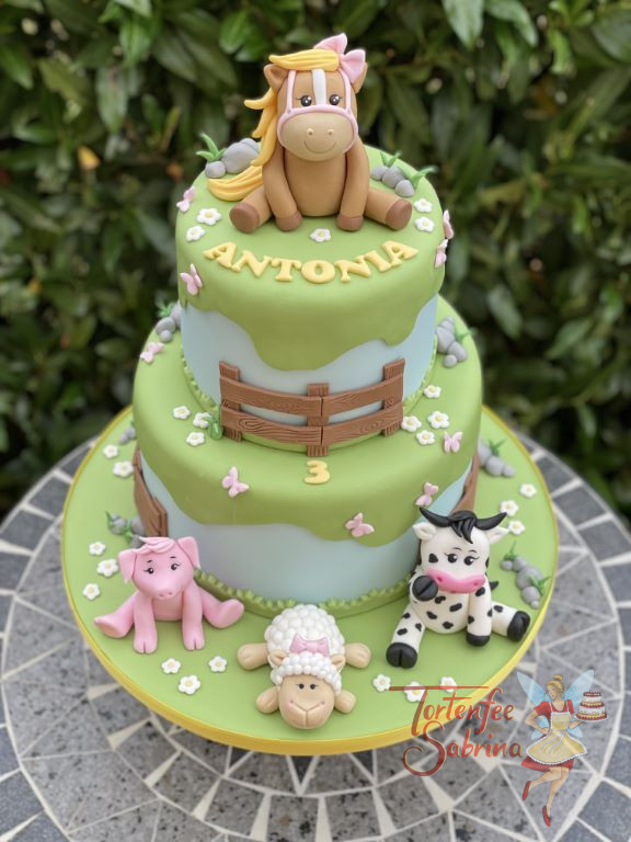 Geburtstagstorte Mädchen - Das Pferdchen mit blonder Mähne sitzt oben auf der Torte, unten seine Freunde das Schwein, das Schaf und die Kuh.