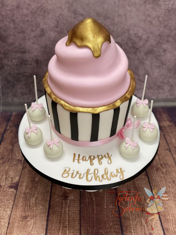 Geburtstagstorte Erwachsene - Der große Cupcake in der schwarz-weißen Form ist ganz oben und seitlich vergoldet.