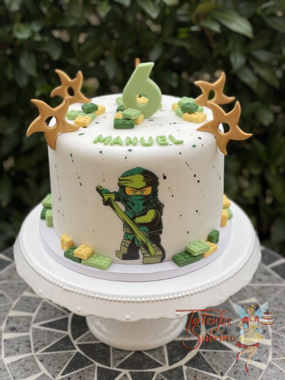 Geburtstagstorte Buben - Der grüne Ninjago Lloyd ziert ganz vorne die Torte, oben sind seine goldenen Wurfsterne zusehen.