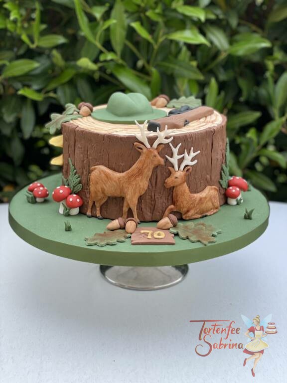 Geburtstagstorte Erwachsene - Der Hirsch und der Jäger dessen Hut und Gewehr auf einem Baumstamm liegt.