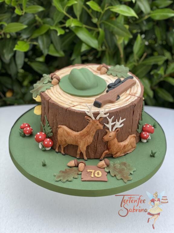 Geburtstagstorte Erwachsene - Der Hirsch und der Jäger dessen Hut und Gewehr auf einem Baumstamm liegt.