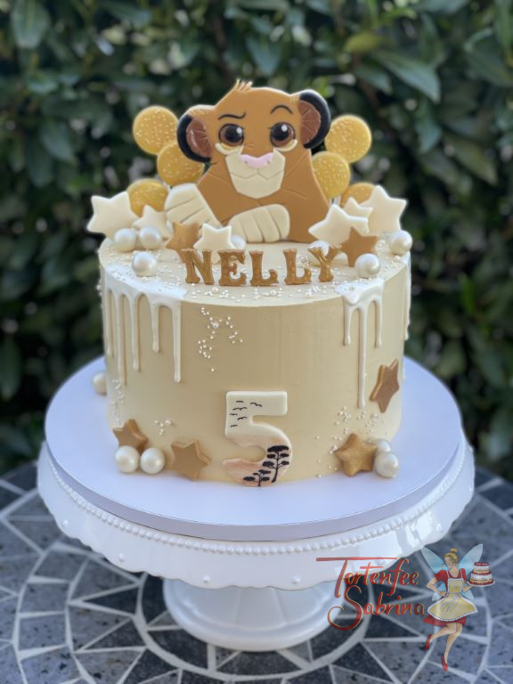 Geburtstagstorte Mädchen - Der süße Löwe Simba tront oben auf der Torte umgeben von Lollies, Sternen und süßen Kugeln.