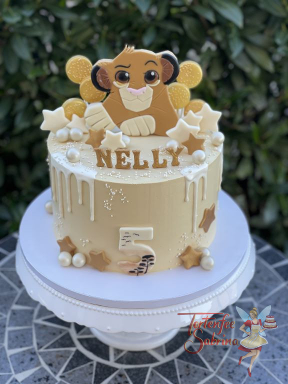 Geburtstagstorte Mädchen - Der süße Löwe Simba tront oben auf der Torte umgeben von Lollies, Sternen und süßen Kugeln.
