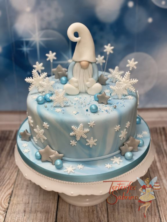 Geburtstagstorte Erwachsene - Der Wichtel im Schnee sitzt mit seinem weißen Bart und Mütze oben auf der Torte.