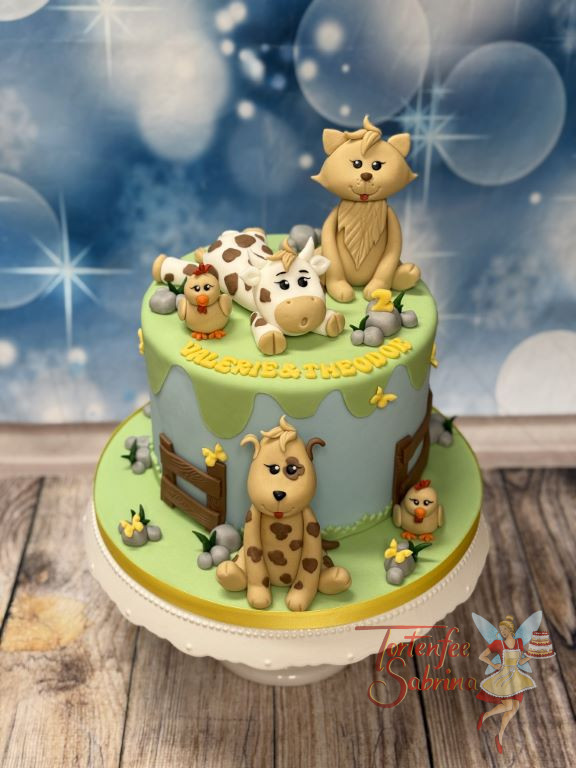 Geburtstagstorte Mädchen und Buben - Die erschöpfte Kuh aber glückliche Kuh liegt oben auf der Torte und freut sich auf ihre Freunde.