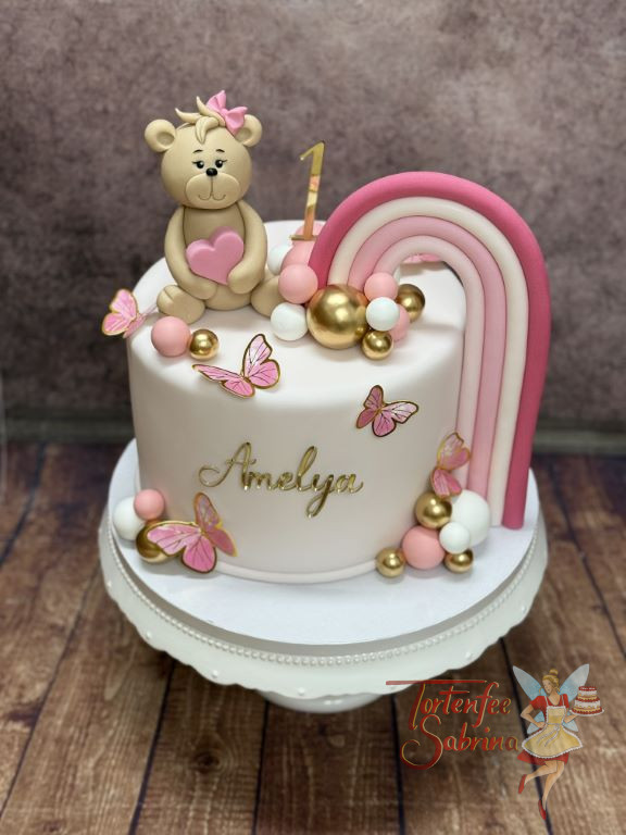 Geburtstagstorte Mädchen - Die goldene 1 verziert neben dem bunten Regenbogen und dem süßen Teddybär die Torte.