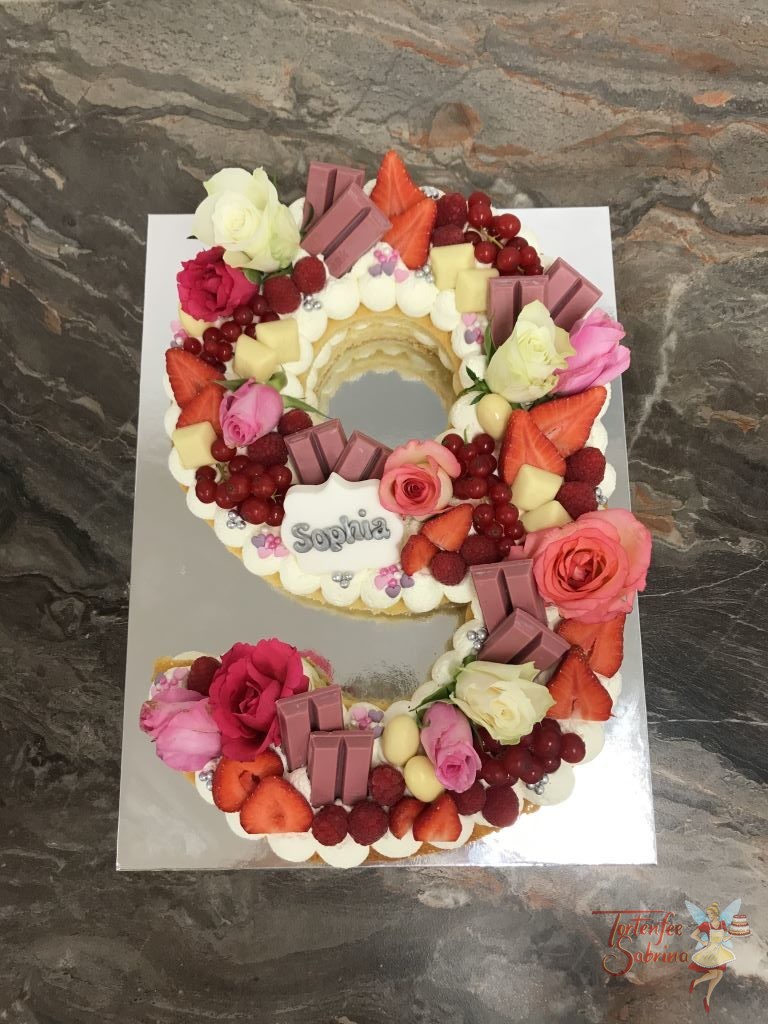 Geburtstagstorte - Die süße 9. Die Zahlentorte wurde mit Rosen, verschiedenen Beeren und unterschiedlichen Süßigkeiten in weiß und rosa.