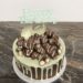 Geburtstagstorte Mädchen - Drip Cake mit vielen süßen Leckereien aus Schokolade gekrönt von einem weißen Drip und einem silbernen Cake Topper