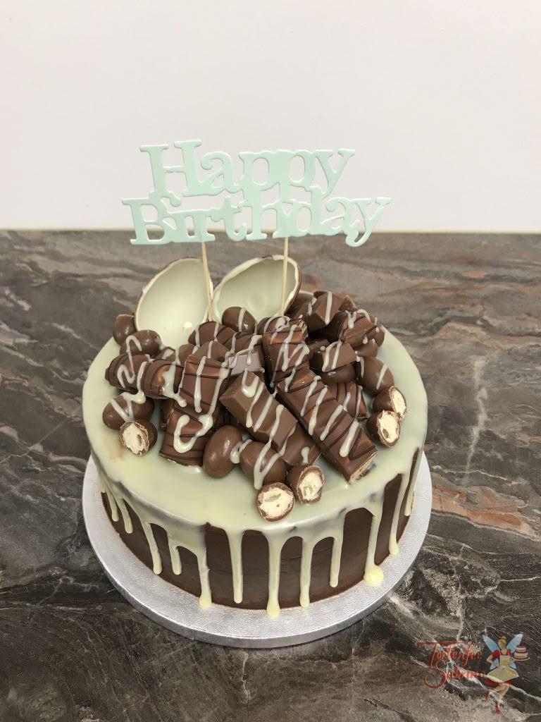 Geburtstagstorte Mädchen - Drip Cake mit vielen süßen Leckereien aus Schokolade gekrönt von einem weißen Drip und einem silbernen Cake Topper