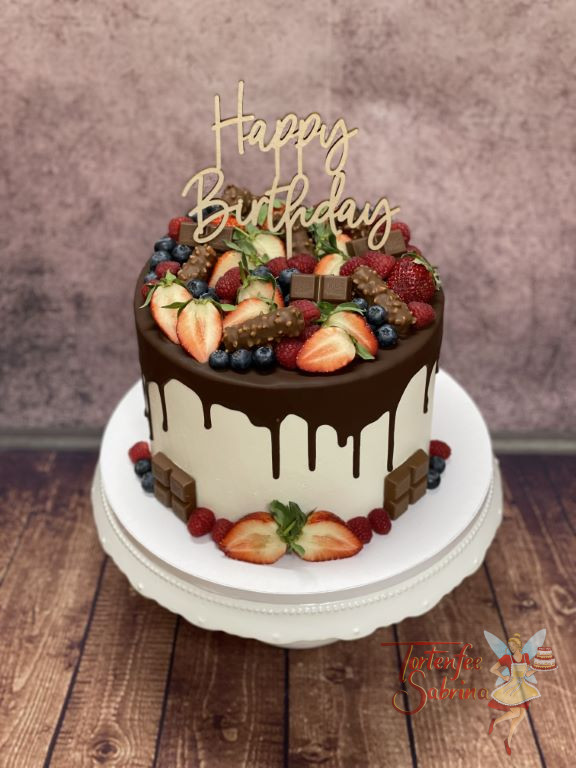 Geburtstagstorte Erwachsene - Drip Cake mit vielen Früchten und Süßem. Ganz oben auf der Torte ziert ein Caketopper die Torte.