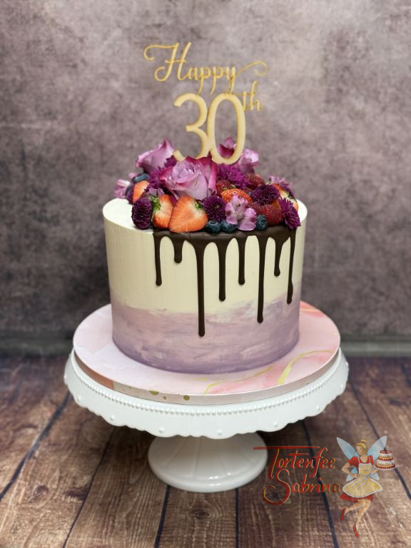 Geburstagstorte Erwachsene - Dunkler Schokodrip sowie violette Blumen verzieren neben den roten Früchten die Torten.