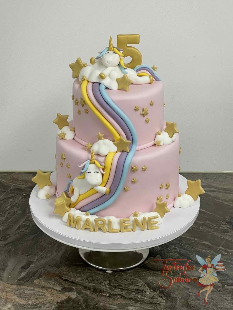 Geburtstagstorte Mädchen - Einhorn auf der Regenbogenrutsche mit vielen goldenen Sternen und Wolken auf einer rosa Torte.