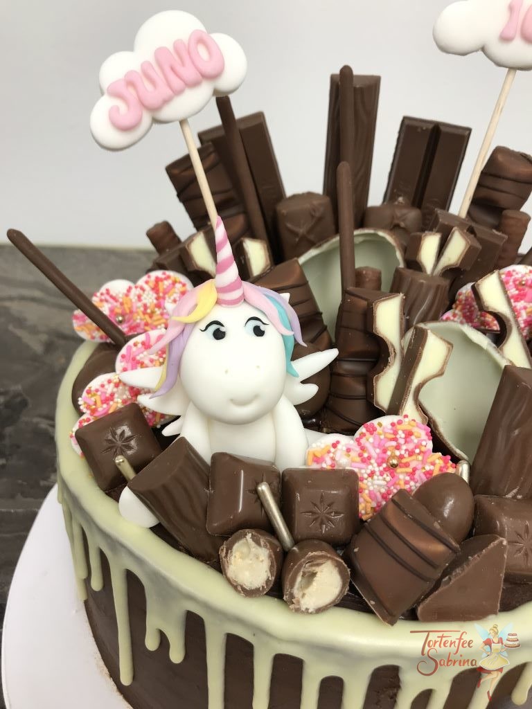 Geburtstagstorte Mädchen - Einhorn im Drip versteckt und schaut zwischen den leckersten Süßigkeiten hervor.