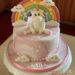 Geburtstagstorte Mädchen - Einhorn mit Wölkchen sitzt vor dem Regenbogen mit Sternchen, die Torte ist rosa und weiß eingedeckt.