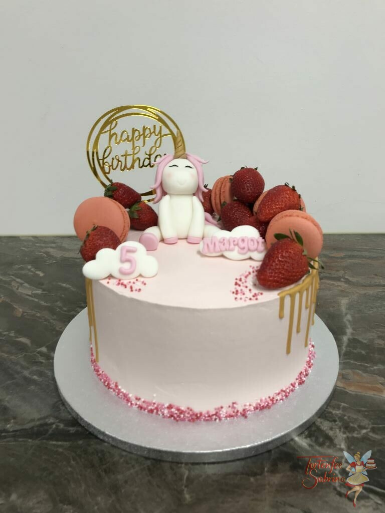 Geburtstagstorte Mädchen - Einhorn zwischen Früchten und Süßem, sitzt oben auf der Torte welche mit einem goldenem Drip und Cake Topper verziert wurde.