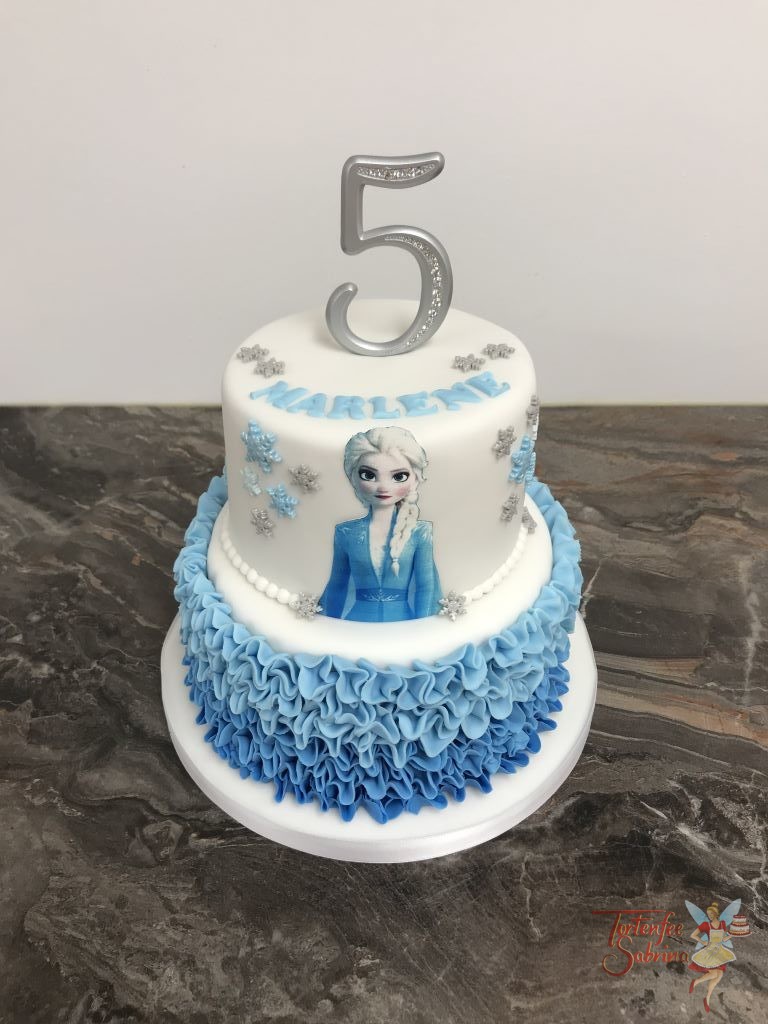 Geburtstagstorte Mädchen - Elsa mit Rüschen in unterschiedlichen Blautönen. Dekoriert mit Elsa, Schneeflocken und einem Cake Topper.
