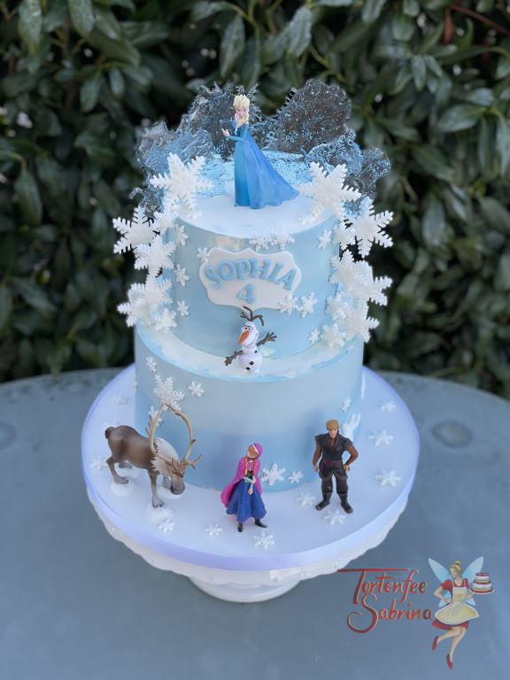 Geburtstagstorte Mädchen - Elsa´s Schneeflocken verteilen sich von oben auf die Torte, darunter stehen Anna, Olaf, Kristoff und Sven.