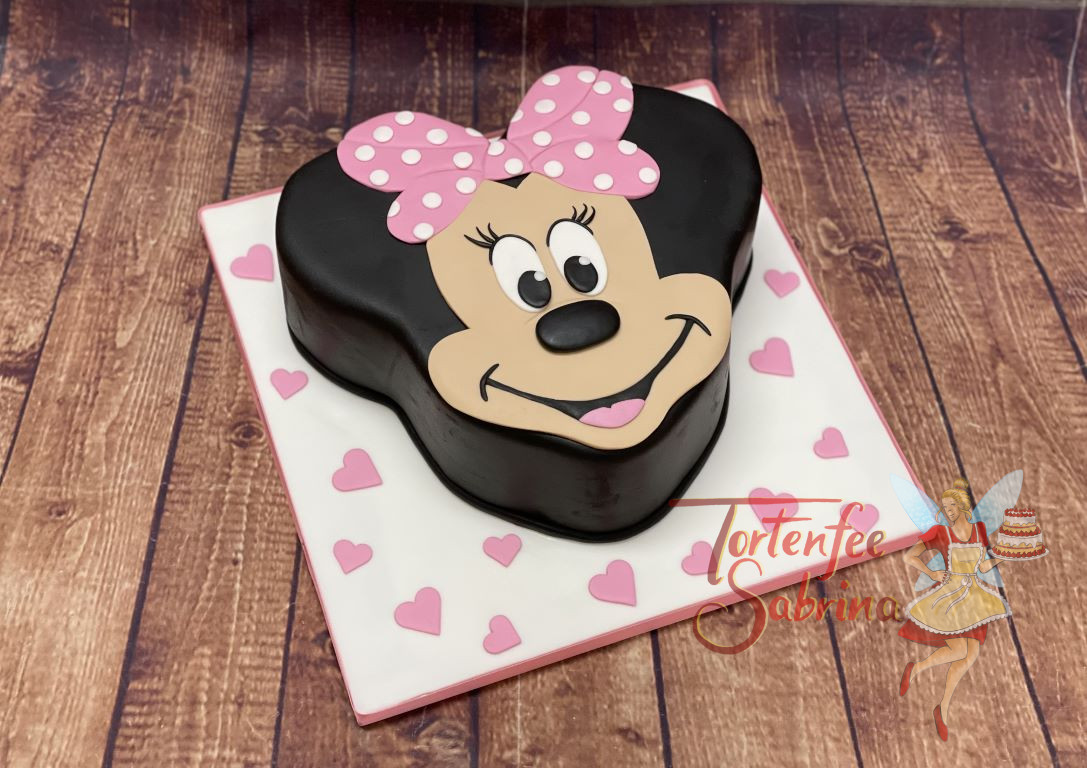 Geburtstagtorte Erwachsene - Entzückende Minnie Mouse lächelt uns in Tortenform entgegen mit ihrer rosa Schleife am Kopf.